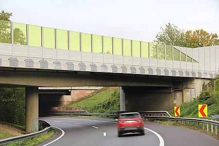 Lärmschutzwand auf einer Brücke aus Aluminium Elementen in Kombination mit gelben Plexiglas Elementen