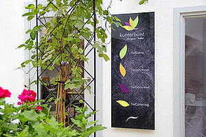 Werbeschild aus Acrylgals im Eingangsbereich des Restaurants "Kunterbunt"