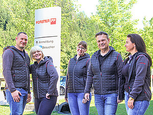 Mitarbeiterinnen und Mitarbeiter, die vor einer Pylone am Forster-Firmenstandort in Waidhofen stehen