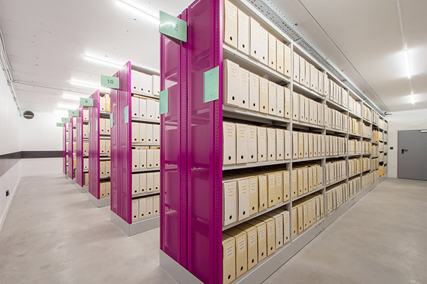 Fachbodenregal mit pinken Vorsatzwänden, gefüllt mit Archivboxen