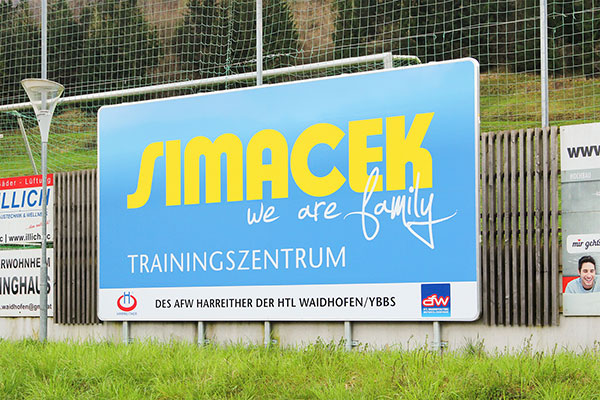 Simcek advertising sign at a sports field 