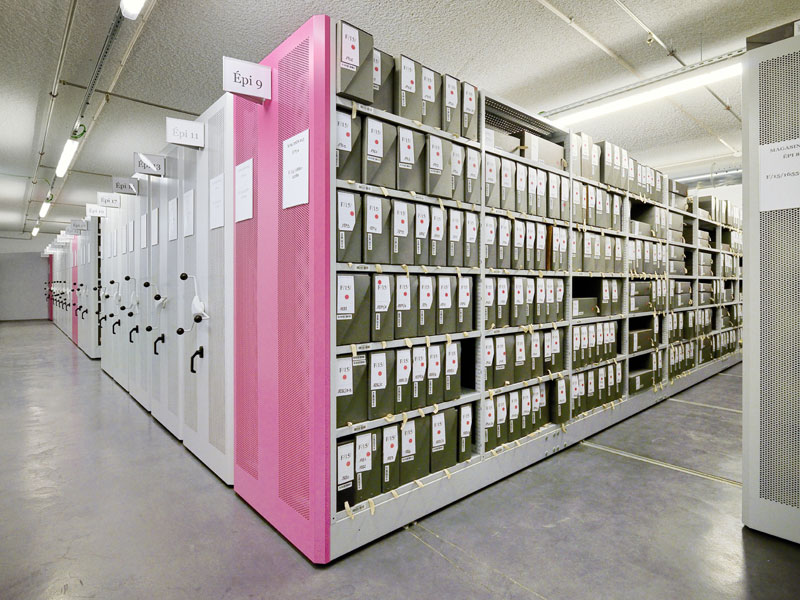 verfahrbare Archivregale mit rosaroten und weißen gelochten Vorsatzwänden