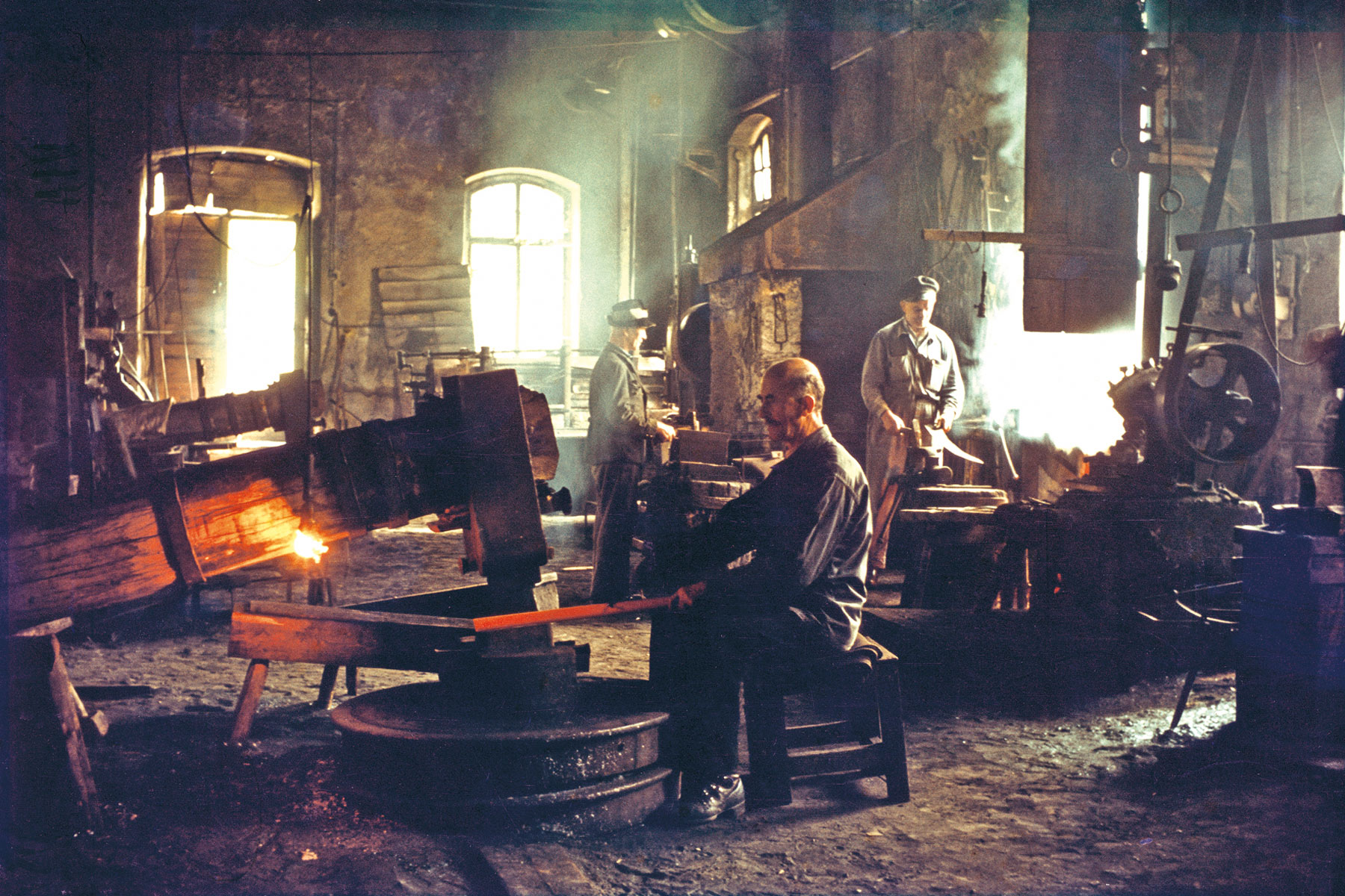 Picture of the scythe hammer factory founded in 1956, a man is working on the scythe hammer